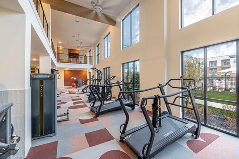 A gym with treadmills and a ceiling fan.