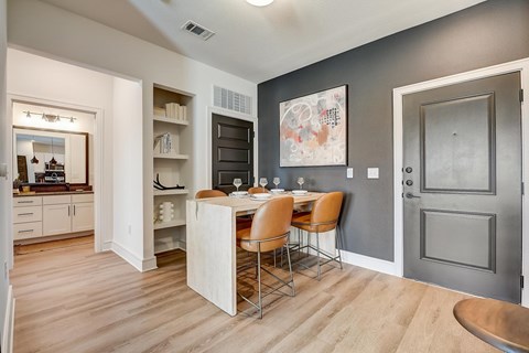 A kitchen with a dining table and chairs in the middle of the room.