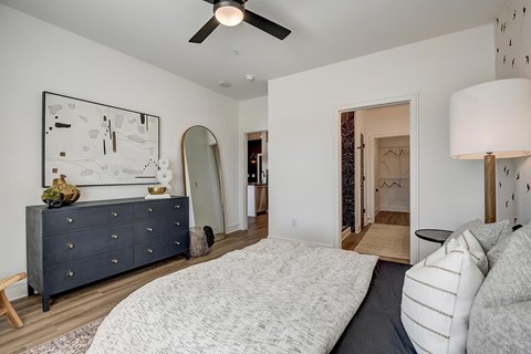 A bedroom with a large bed and a dresser with a mirror.