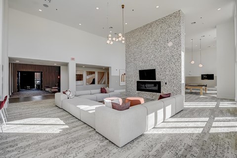A modern living room with a white sofa and a grey patterned wall.