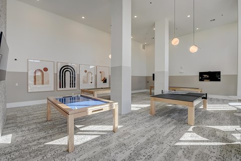 A room with a pool table and a shelf with a television.