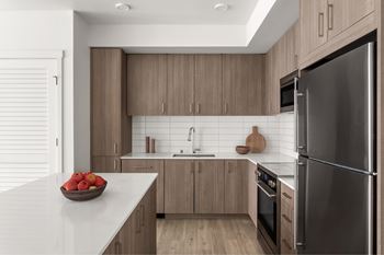 A modern kitchen with a bowl of apples on the counter.