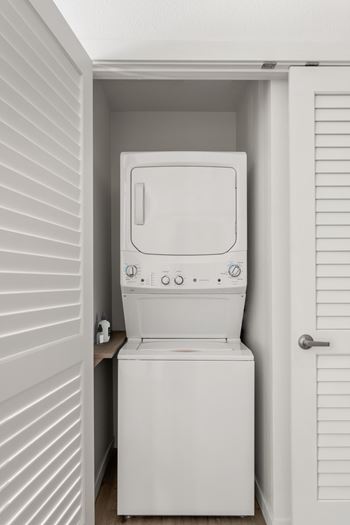 A white toilet is installed in a small white room.