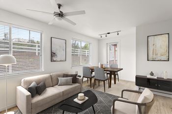 A living room with a grey couch, a black coffee table, and a ceiling fan.