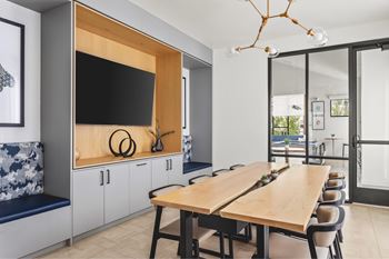 A modern dining room with a wooden table and chairs.