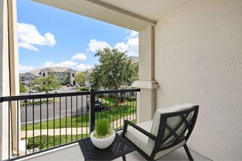 A balcony with a chair and a potted plant.