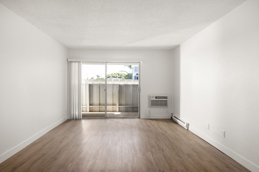 A room with a sliding glass door leading to a balcony.