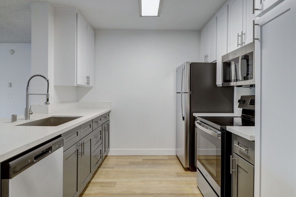 A kitchen with white cabinets and black appliances.
