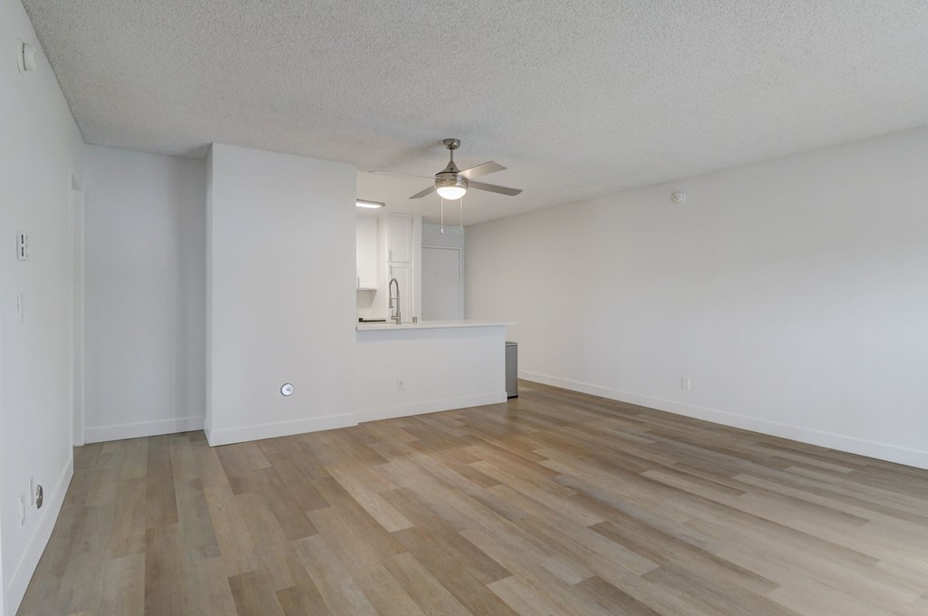 A room with wooden flooring and a ceiling fan.