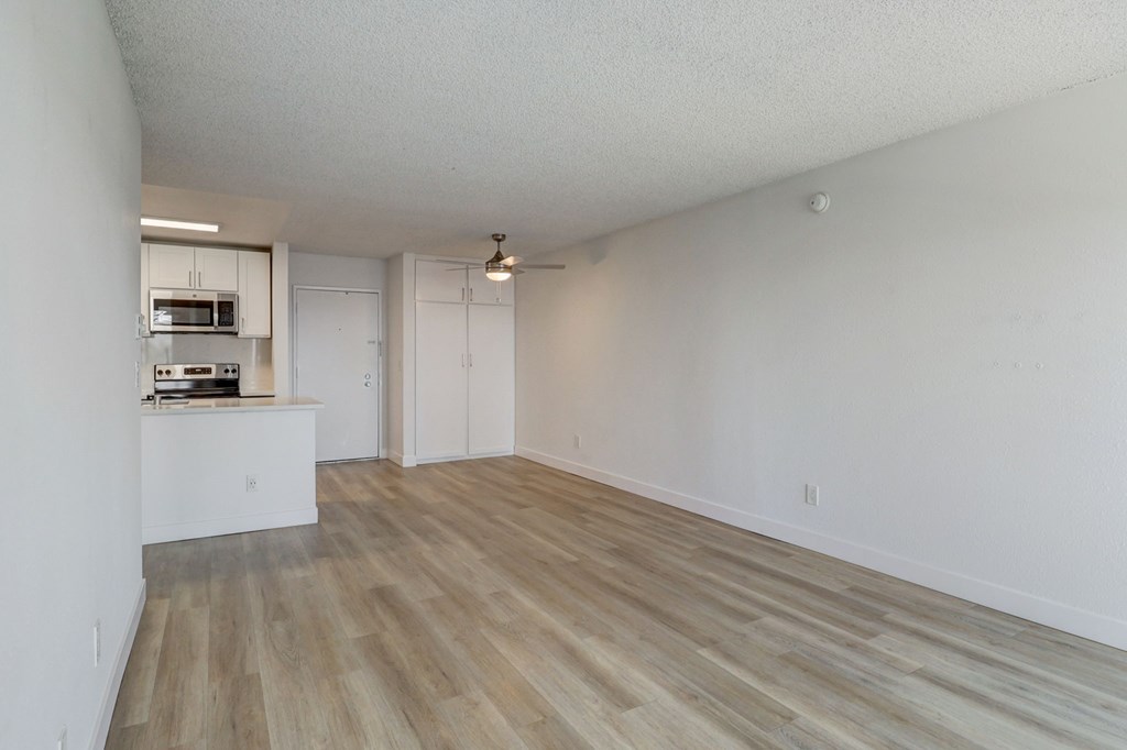 A room with a kitchenette and a dining table.