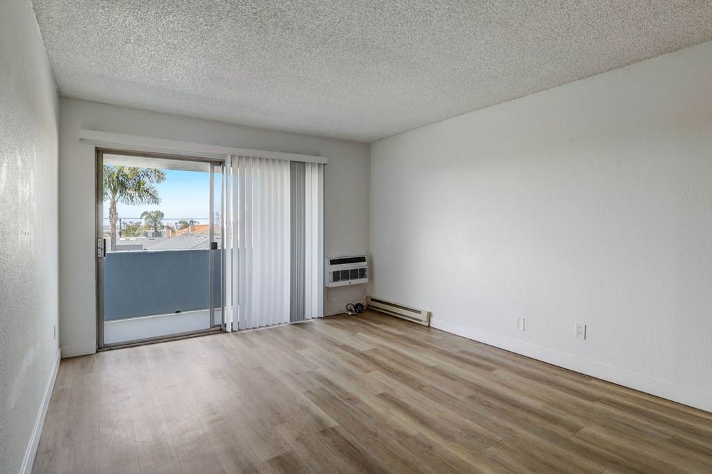 A room with a sliding glass door leading to a balcony.