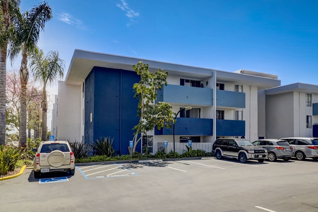 A modern building with a parking lot in front of it.