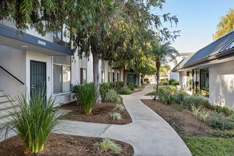 A pathway leads through a landscaped courtyard between two rows of buildings.