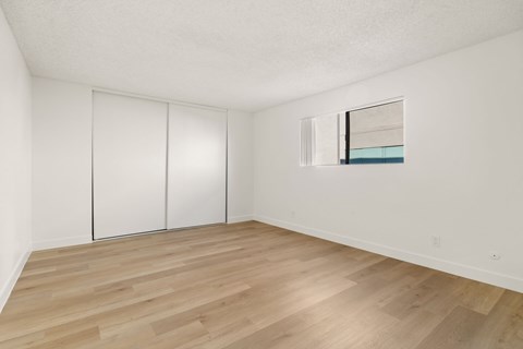 A room with a white wall and a wooden floor.