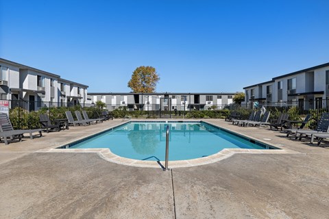 A swimming pool in front of apartment buildings.