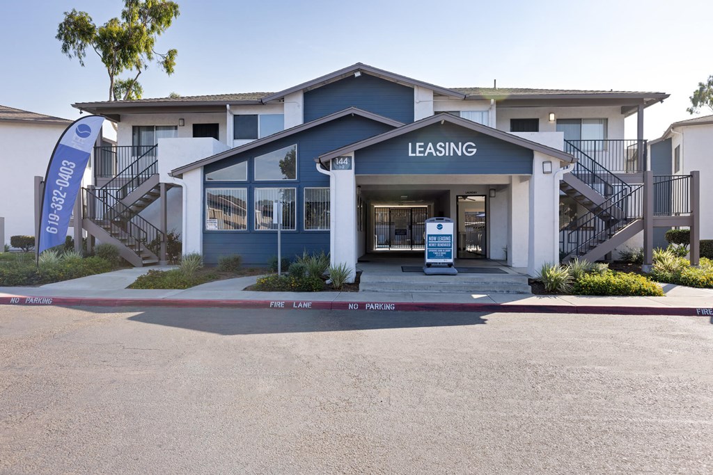A leasing office is located in front of a two-story apartment building.