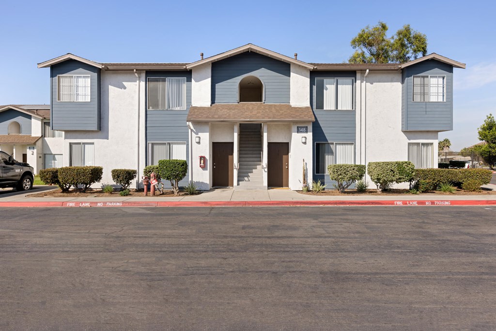 A large building with a grey and white facade and a brown roof.