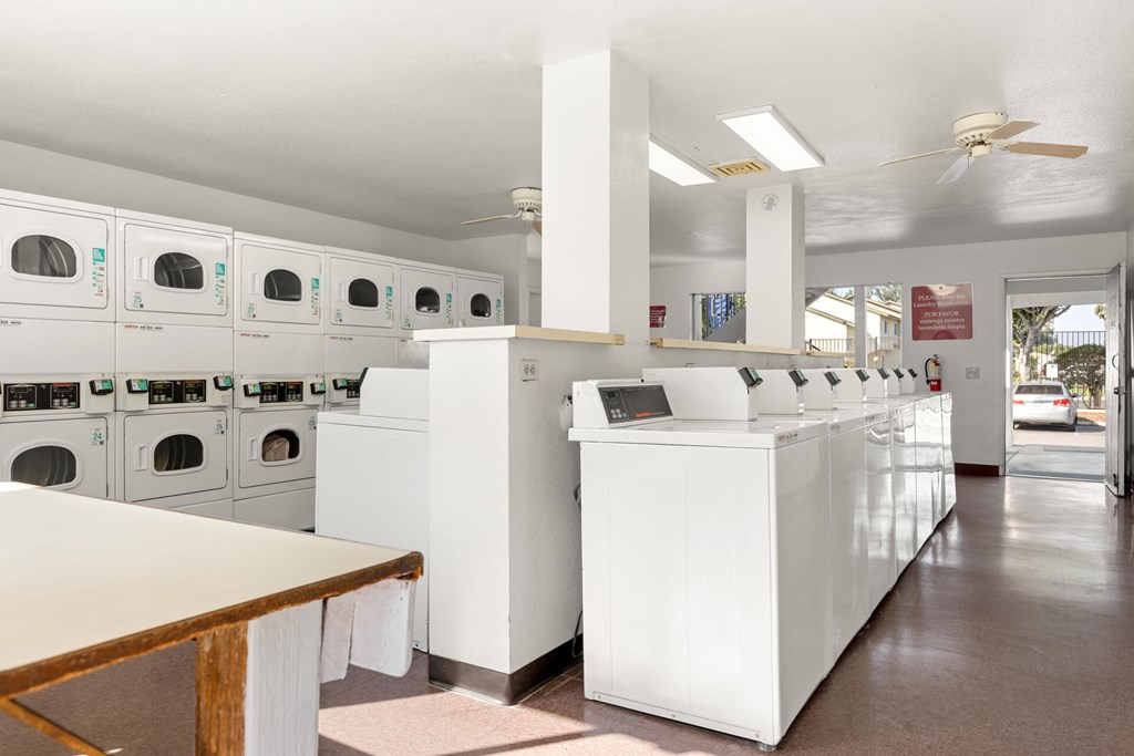 A laundromat with a row of washers and dryers.