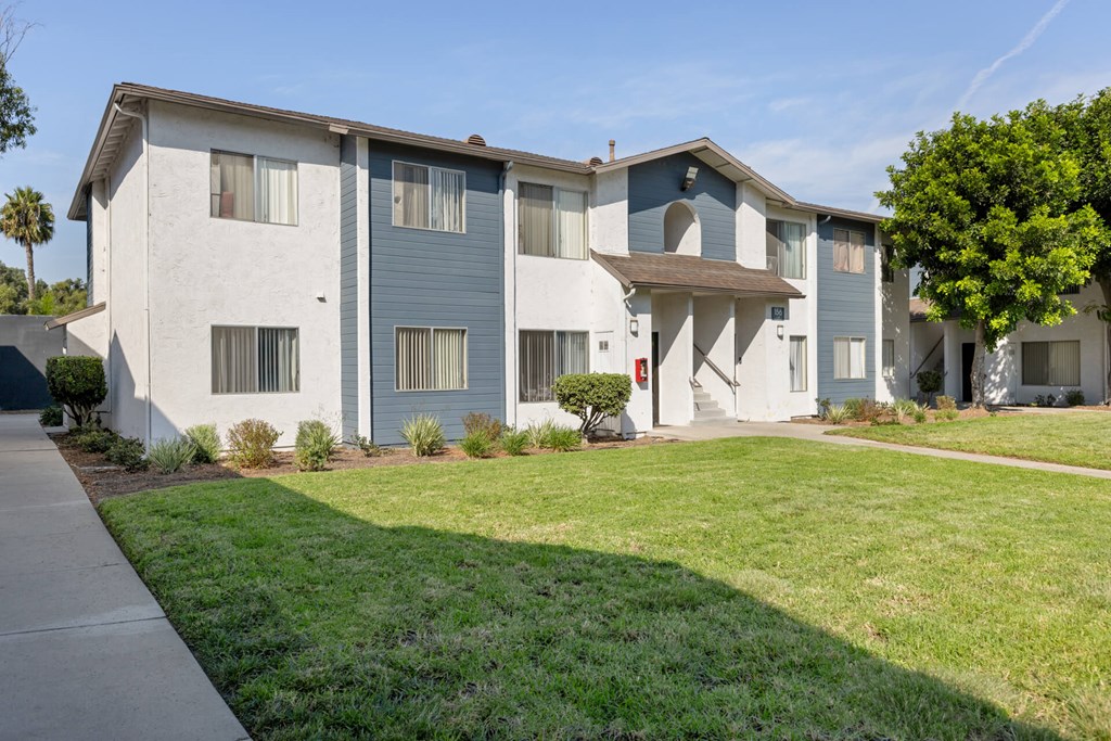 Apartment building with a green lawn in front.