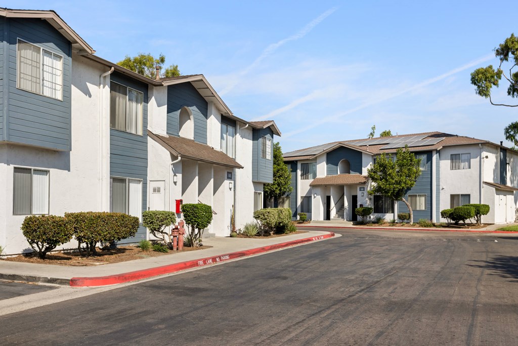 A row of apartment buildings with a red curb in front.