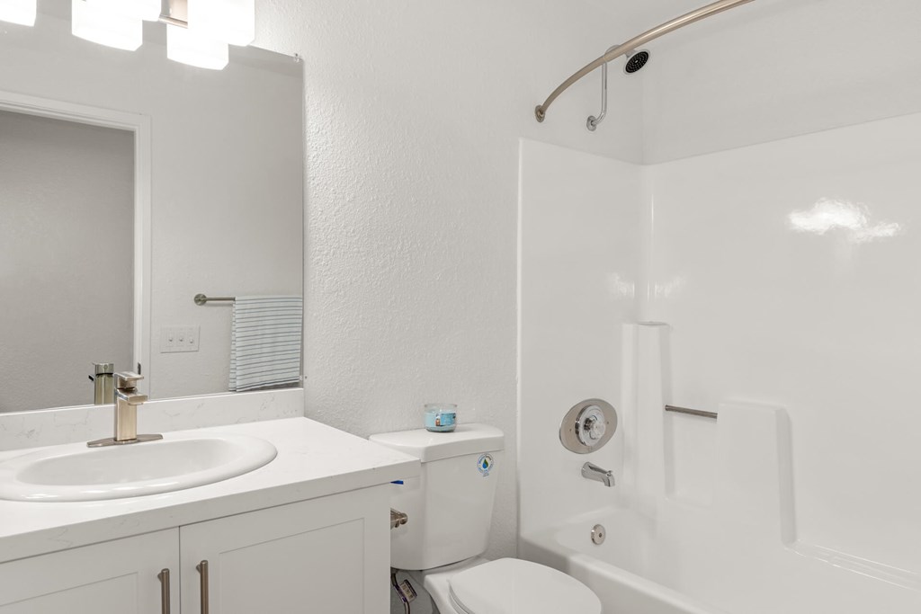 A white bathroom with a sink, toilet, and bathtub.