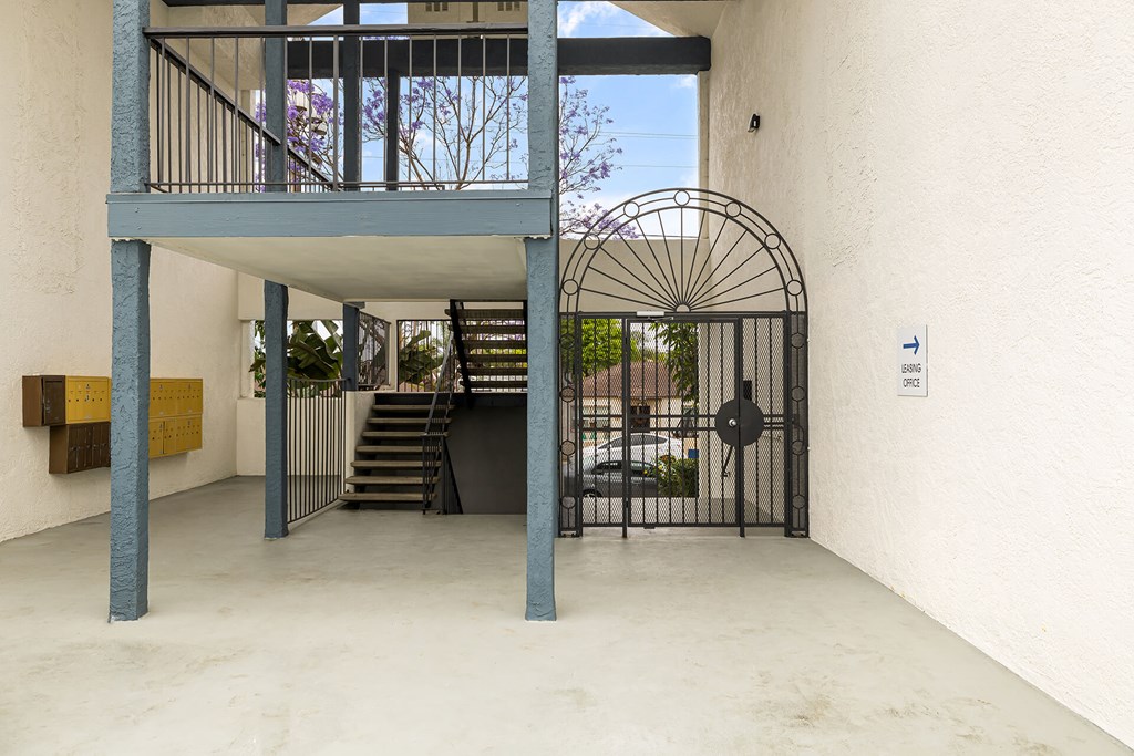 A white building with a gate and a staircase.