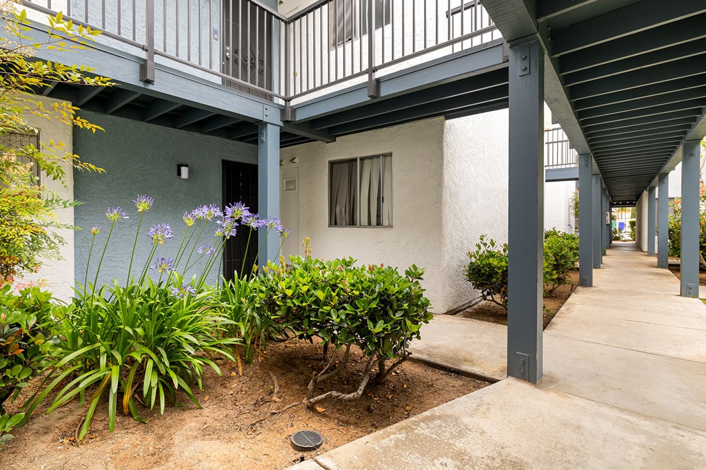 A patio area with a white building and a concrete floor.