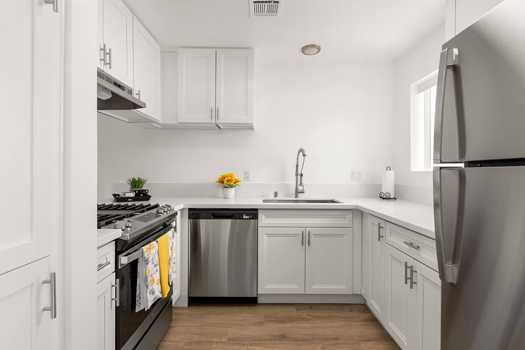 A modern kitchen with white cabinets and stainless steel appliances.