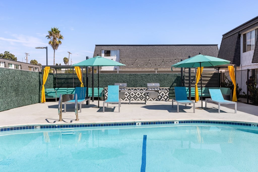 A pool with a blue line in the middle and a green umbrella.