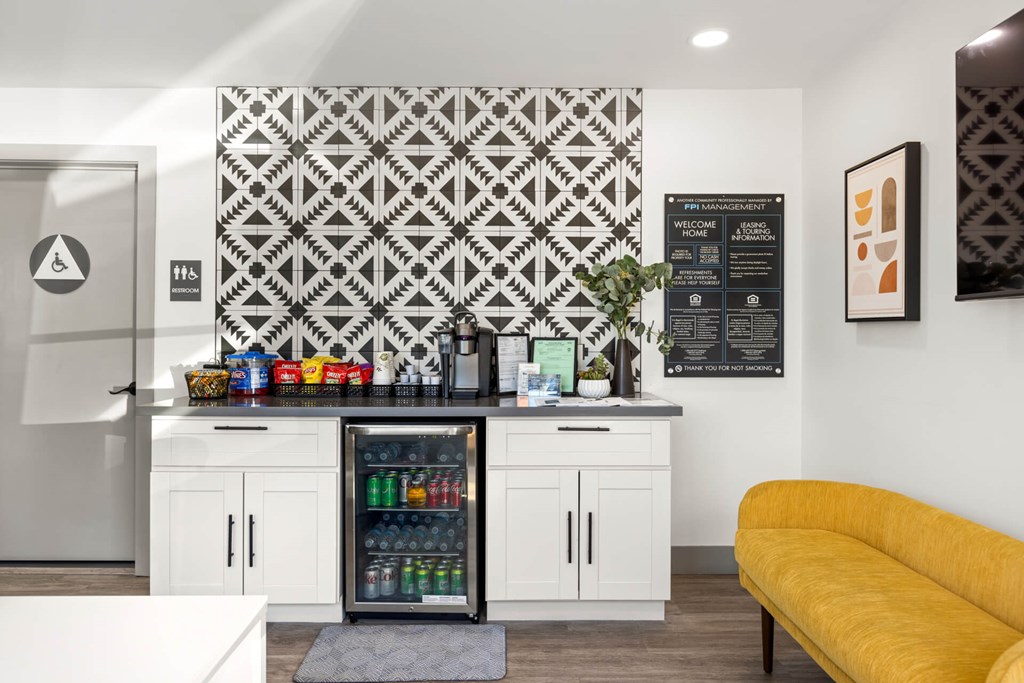 A kitchen with a yellow couch and a patterned wallpaper.