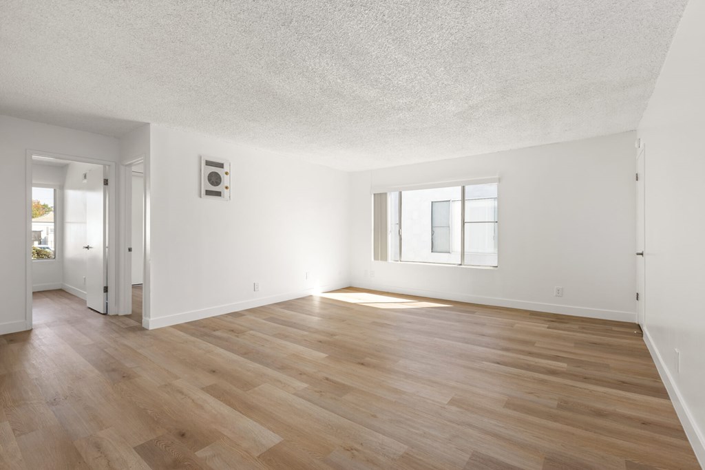 A room with wooden flooring and a window.