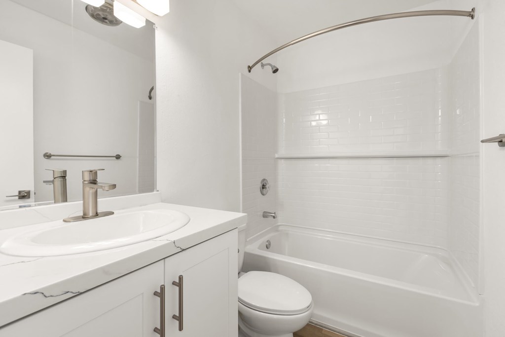 A white bathroom with a sink, toilet, and bathtub.