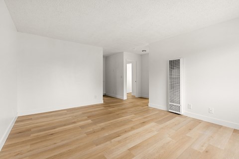A room with wooden flooring and white walls.