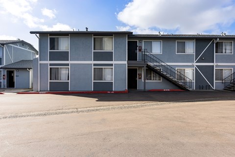 A large grey building with a black staircase in front.