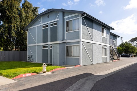 A grey building with a red no parking sign in front of it.