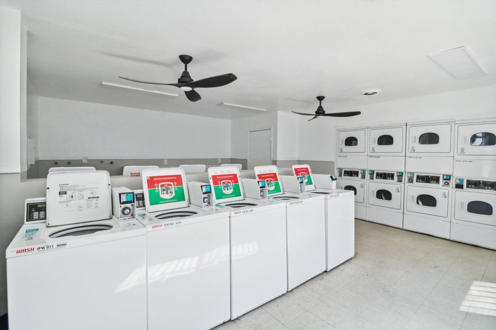 A row of white dishwashers are lined up in a store.