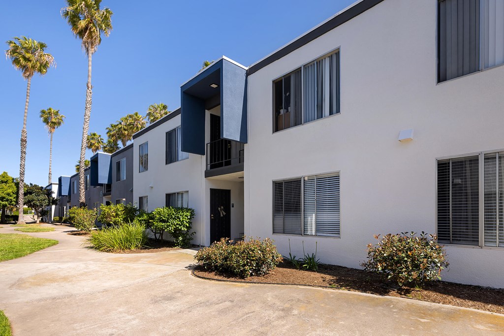 A row of modern houses with white walls and dark blue trim.