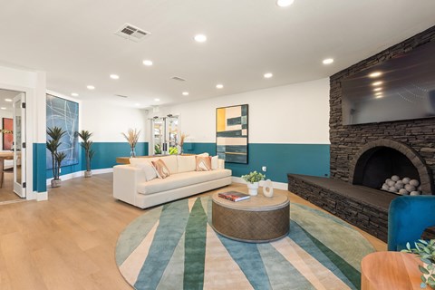 A living room with a white couch and a fireplace.