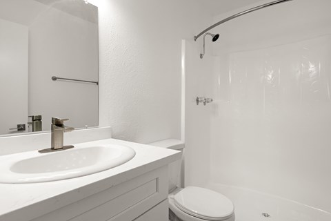 A white bathroom with a toilet and sink.