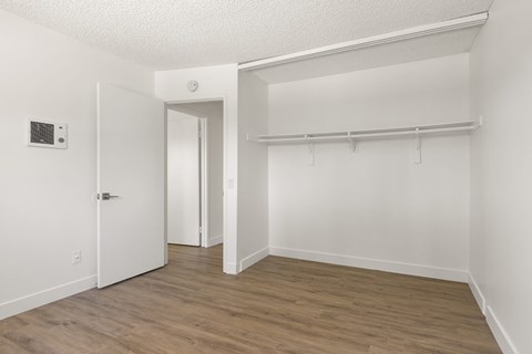 A room with a white door and a white wall with a switch.