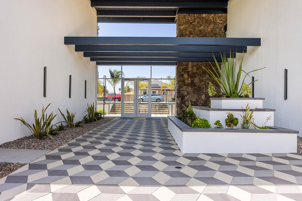 A checkered patterned walkway leads to a building entrance.