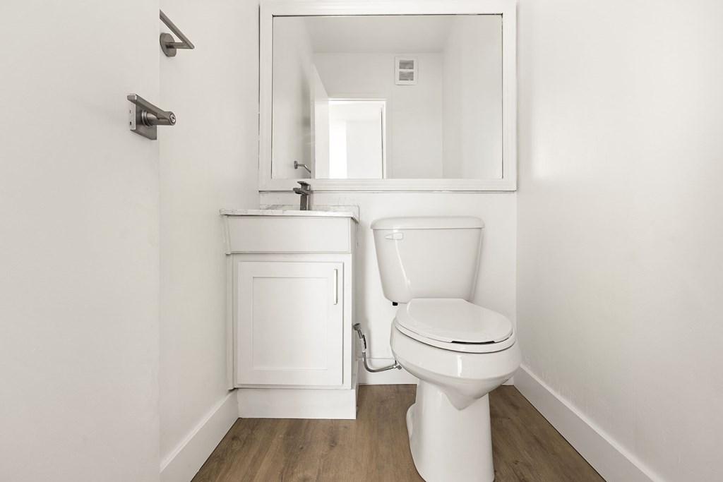 A white toilet and sink in a small bathroom.