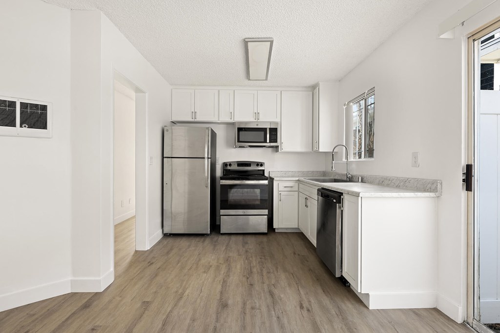 A modern kitchen with stainless steel appliances and white cabinets.