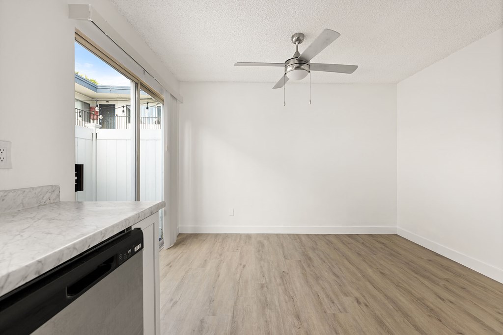 A room with a ceiling fan and a marble countertop.