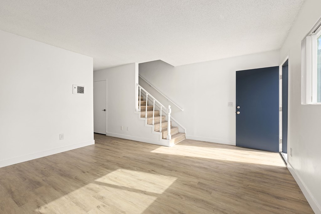 A room with a staircase leading to another room.