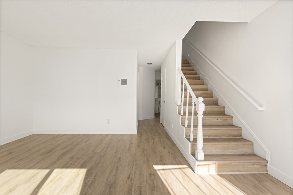 A room with a staircase leading to another room.