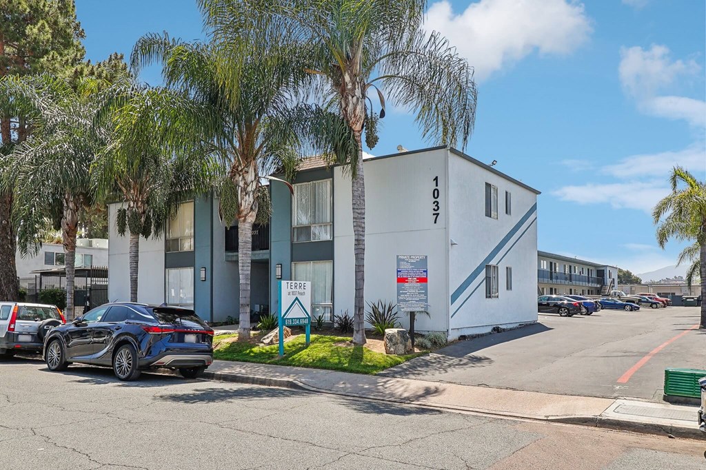 A modern building with the number 1037 on it is surrounded by palm trees.