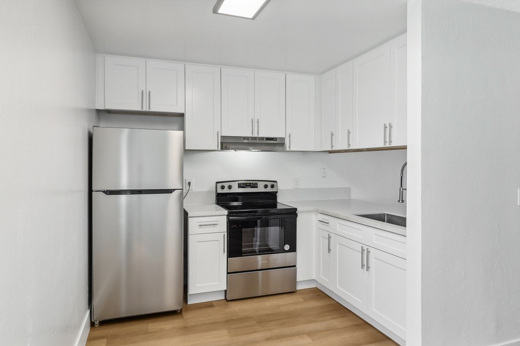 A kitchen with white cabinets and stainless steel appliances.