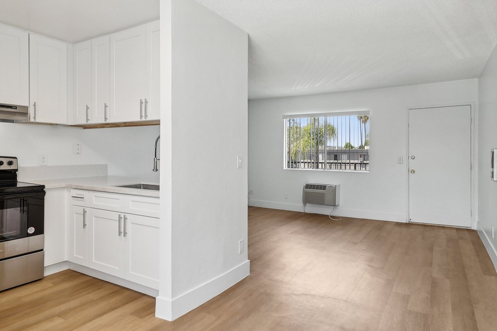 A kitchen with white cabinets and a window.