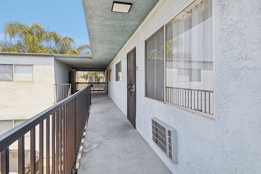 A balcony with a railing and a door with a window above it.